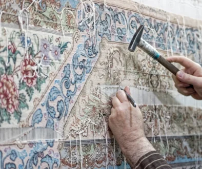 Člověk opravuje perský koberec.