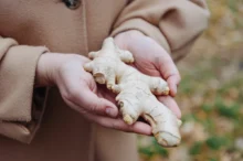 Žena drží v ruce zázvor.