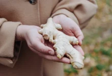 Žena drží v ruce zázvor.