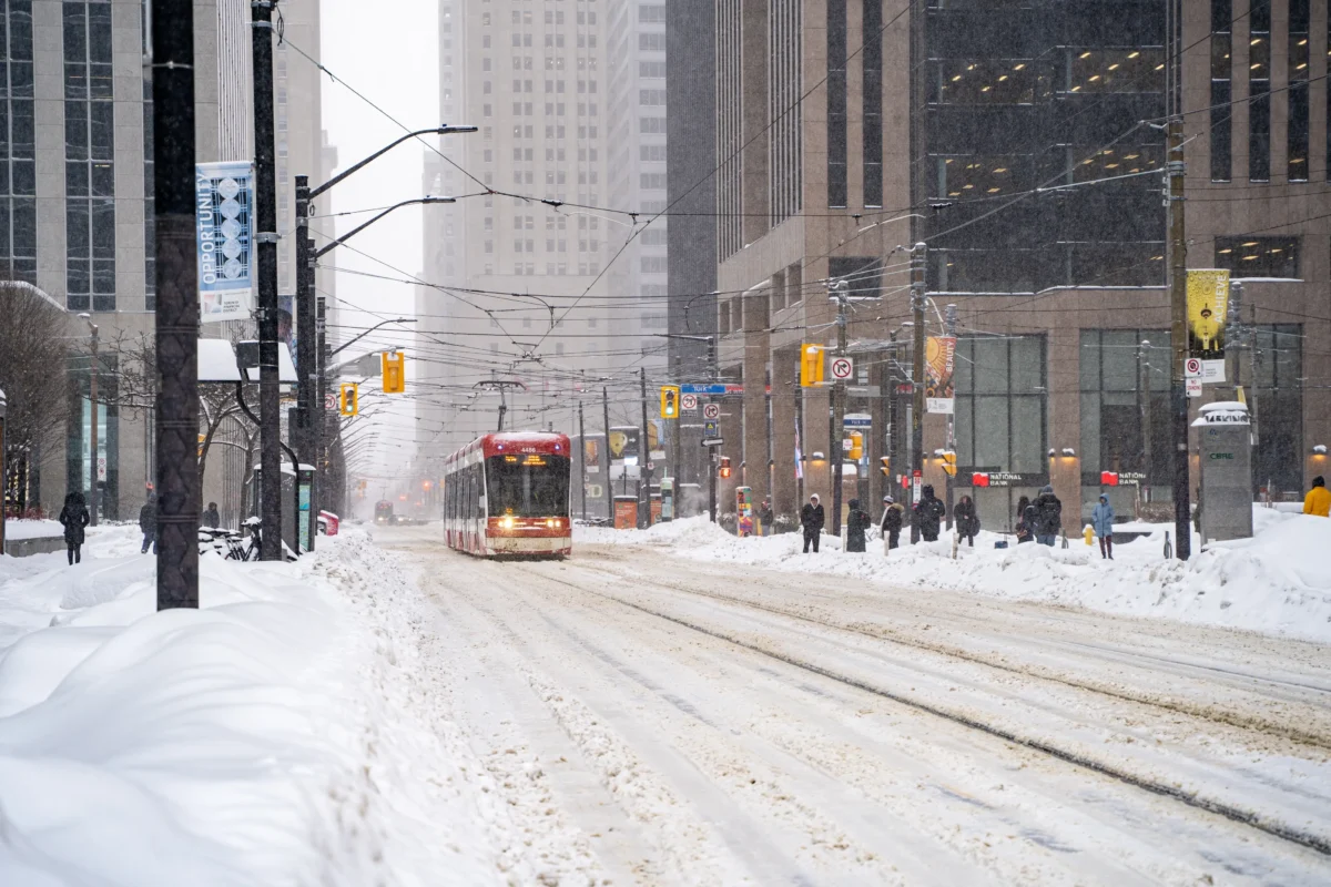 shutterstock_2592173169-2 | TVGURU.cz Tramvaj projíždí zasněženým kanadským městem.