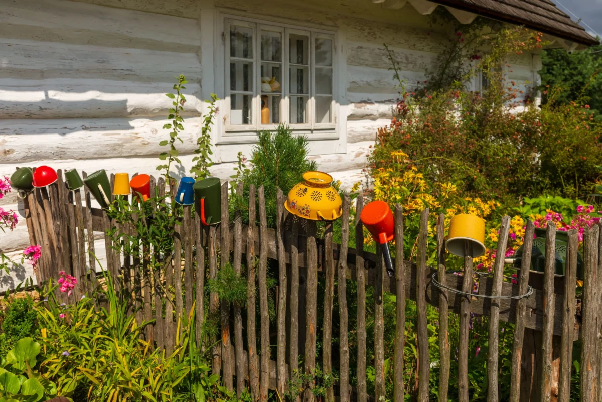 barevné retro nádobí pověšené na plotě
