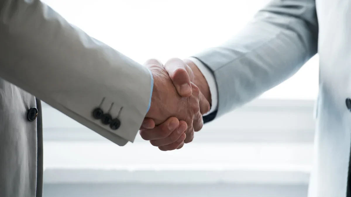 Muži si třesou rukou.
