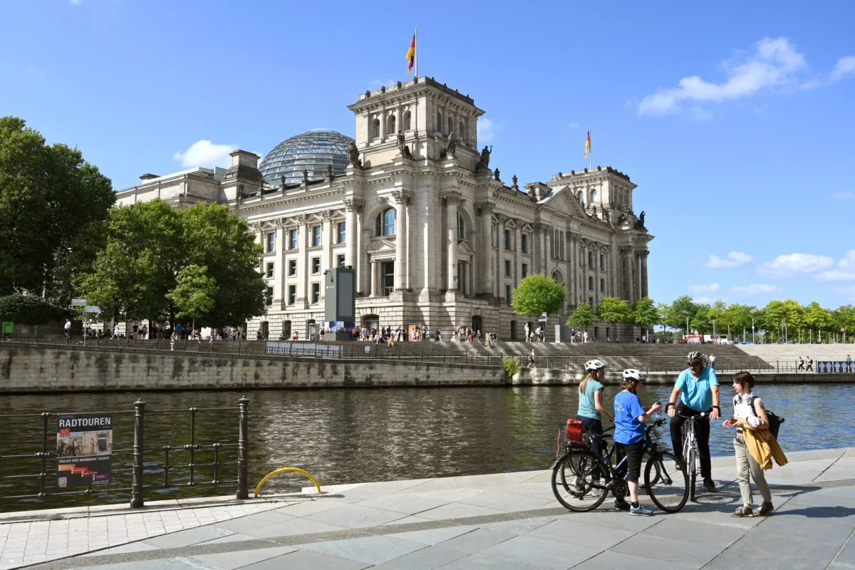 Lidé s kolem obdivují berlínskou památku.