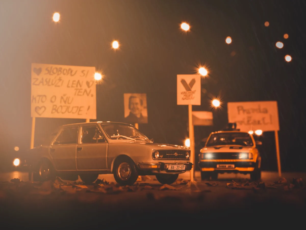 Auta parkují mezi cedulemi. 