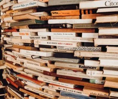 Na sobě jsou vyskládané knihy.