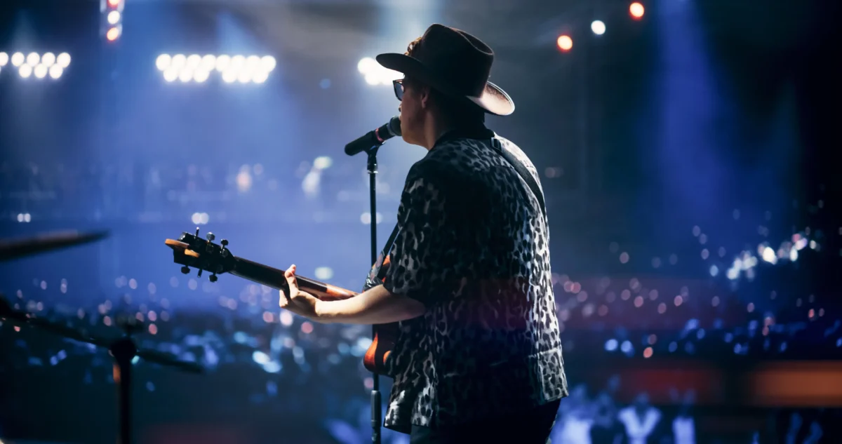 Muž zpívá na pódiu. 