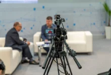 Natáčení dvou mužů, kteří sedí na gauči.