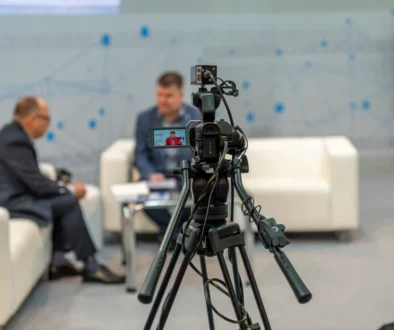 Natáčení dvou mužů, kteří sedí na gauči.