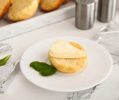 Na talíři je nandané pečivo s taveným sýrem.