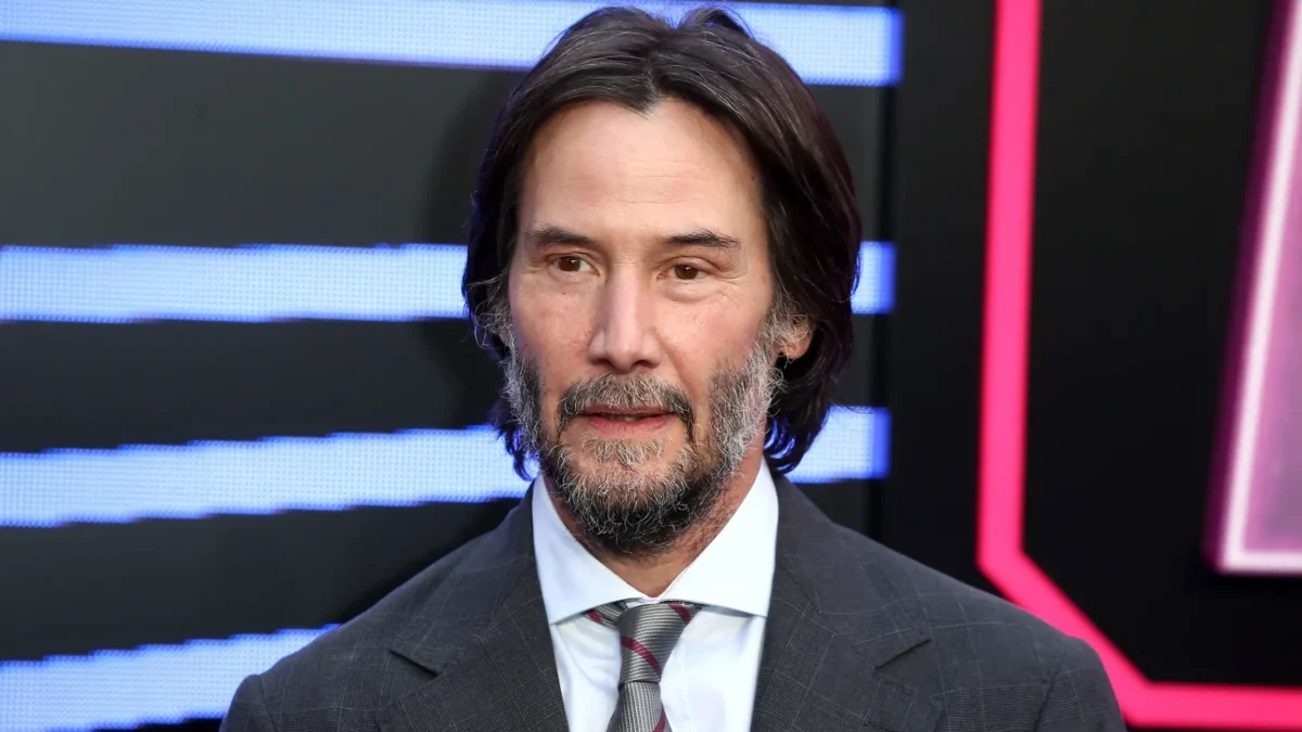 Keanu Reeves pózuje na fotku.