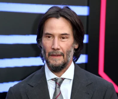 Keanu Reeves pózuje na fotku.