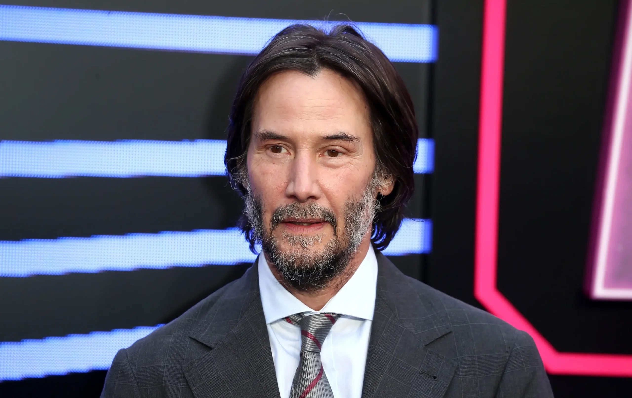Keanu Reeves pózuje na fotku.