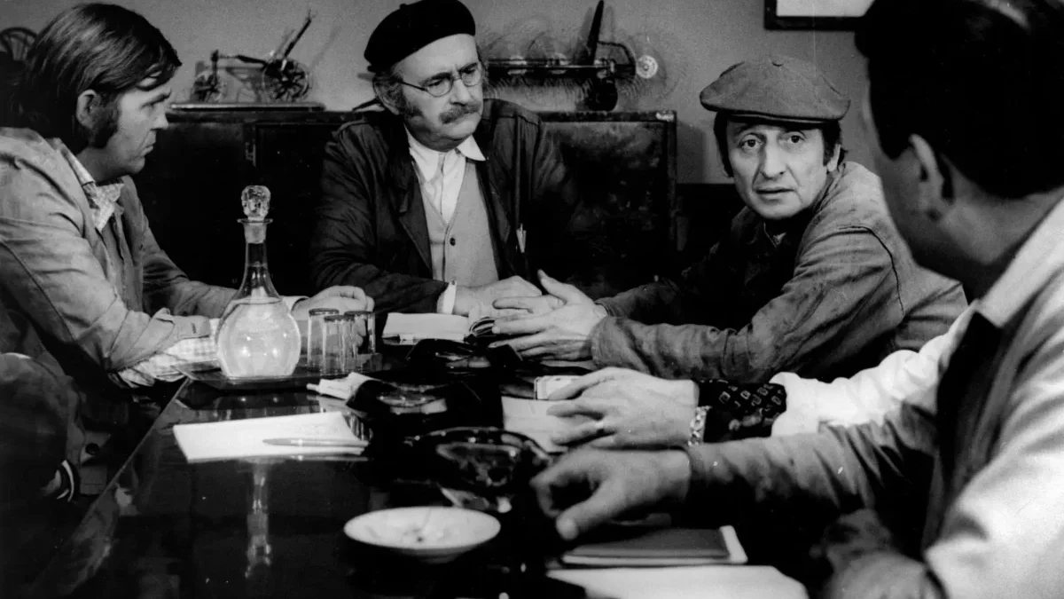 Muži sedí u stolu.