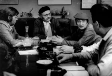 Muži sedí u stolu.