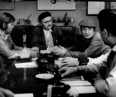 Muži sedí u stolu.