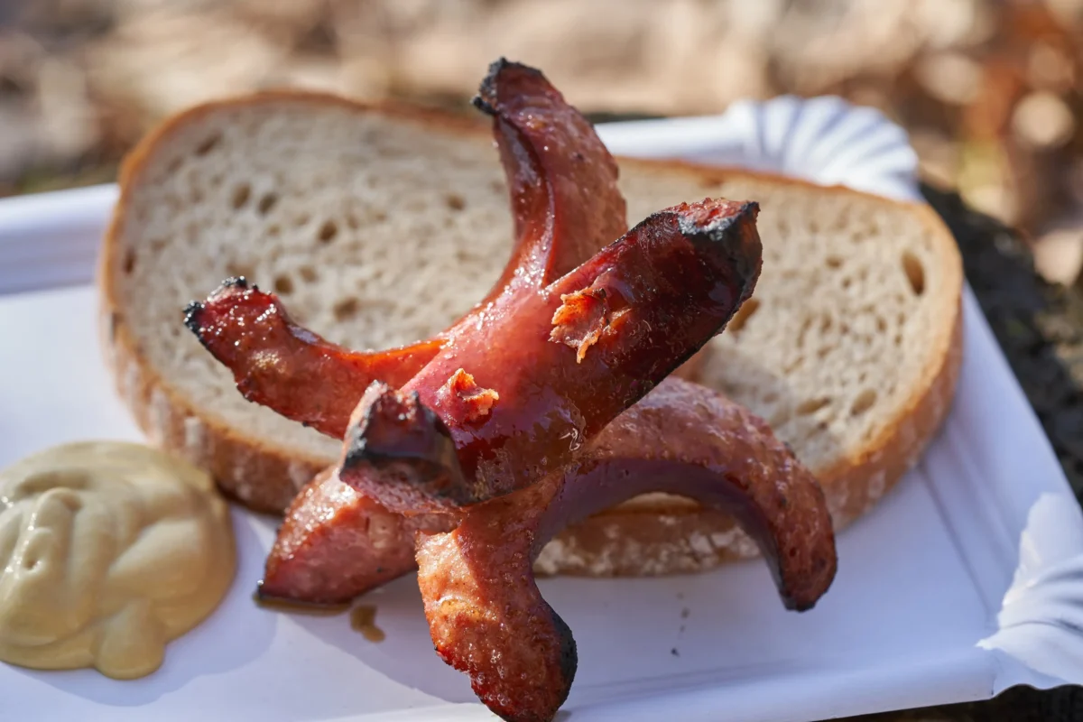 Na tácku je nandaný chléb se špekáčky. 