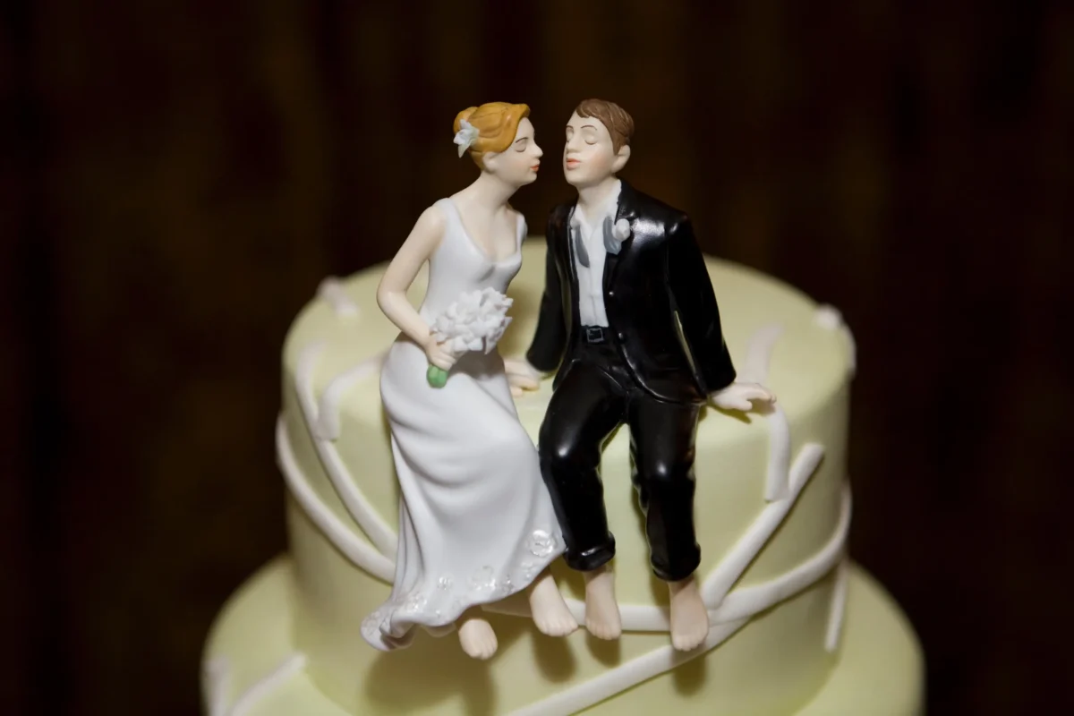 Na dortu sedí postavička nevěsty a ženicha.