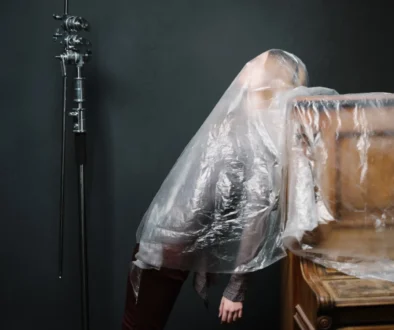 Žena je zahalená igelitem u klavíru.