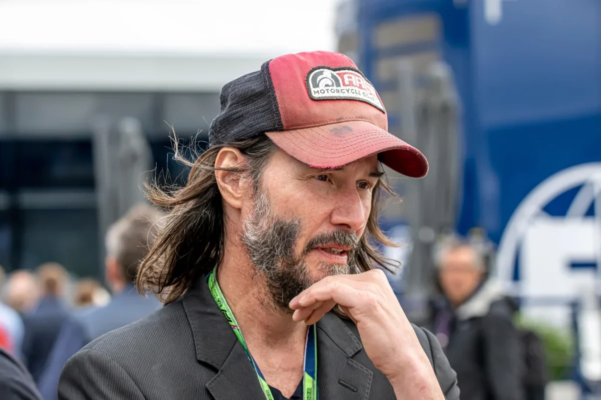 Keanu Reeves si podpírá hlavu.