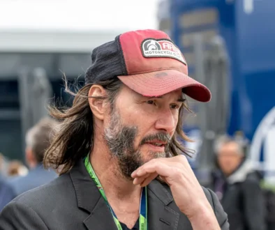 Keanu Reeves si podpírá hlavu.