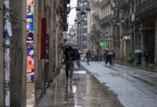 Lidé se v dešti prochází Barcelonou.