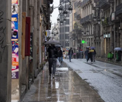 Lidé se v dešti prochází Barcelonou.