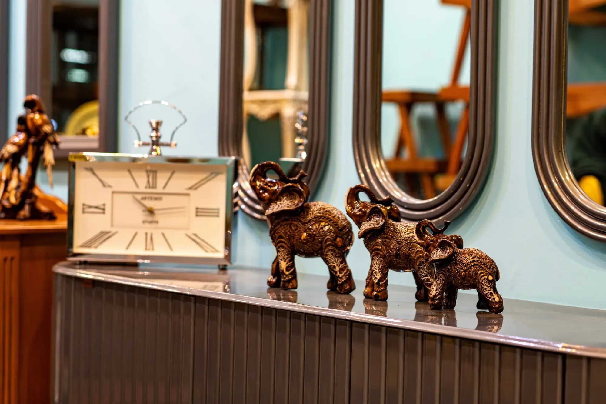 Vintage sošky slonů vystavené na skříni.