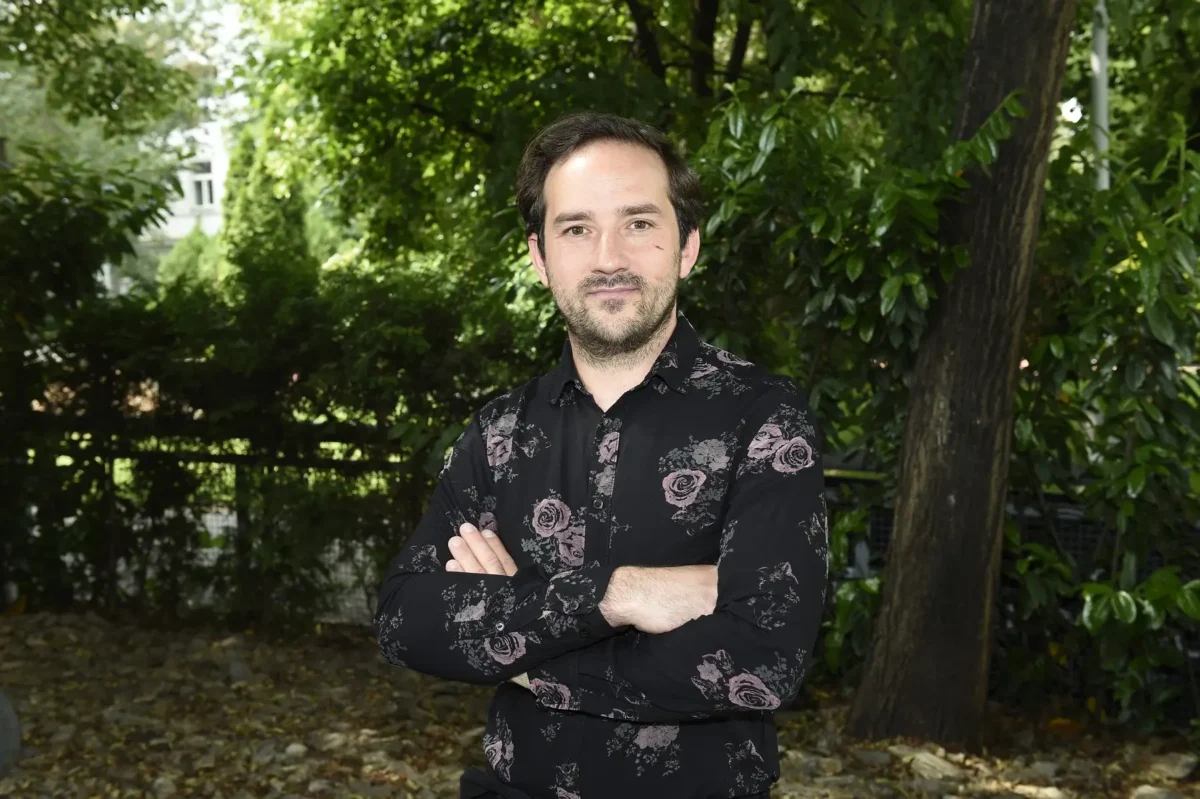 Matouš Ruml stojí venku pod stromem. 