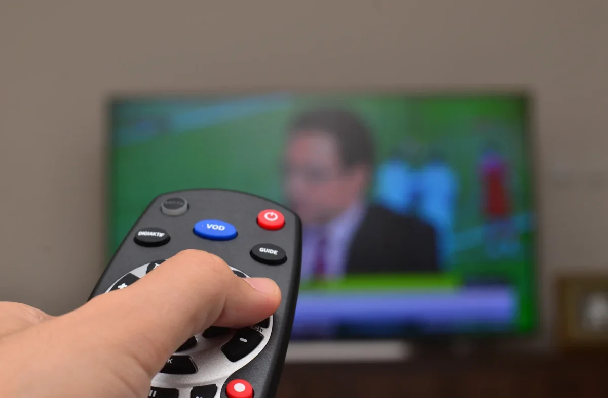 Člověk ovladačem míří na TV.