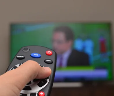 Člověk ovladačem míří na TV.