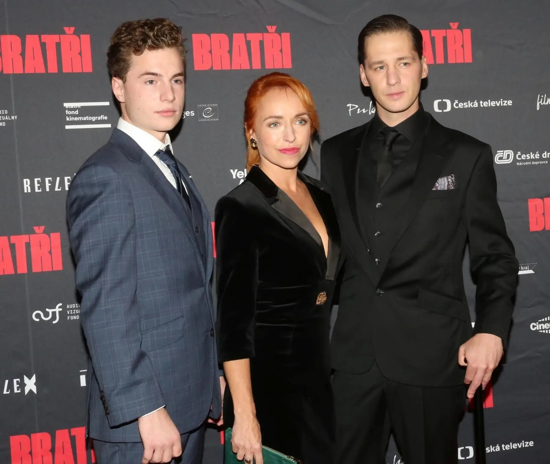 Tři herci stojí vedle sebe na premiéře.