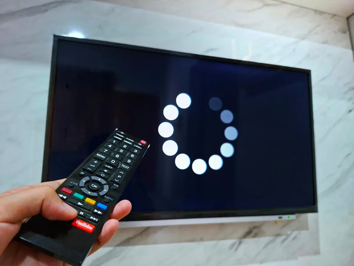 Člověk ovladačem míří na TV.