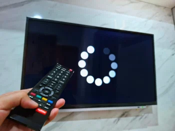 Člověk ovladačem míří na TV.