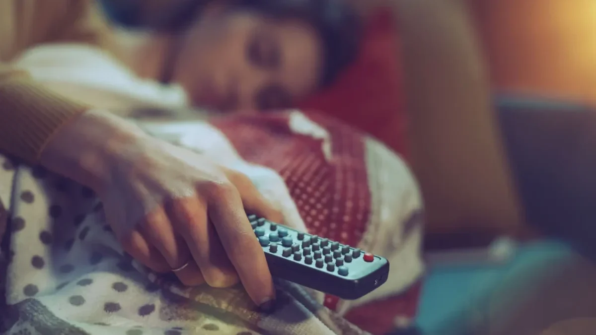 Žena spí s ovladačem v ruce.