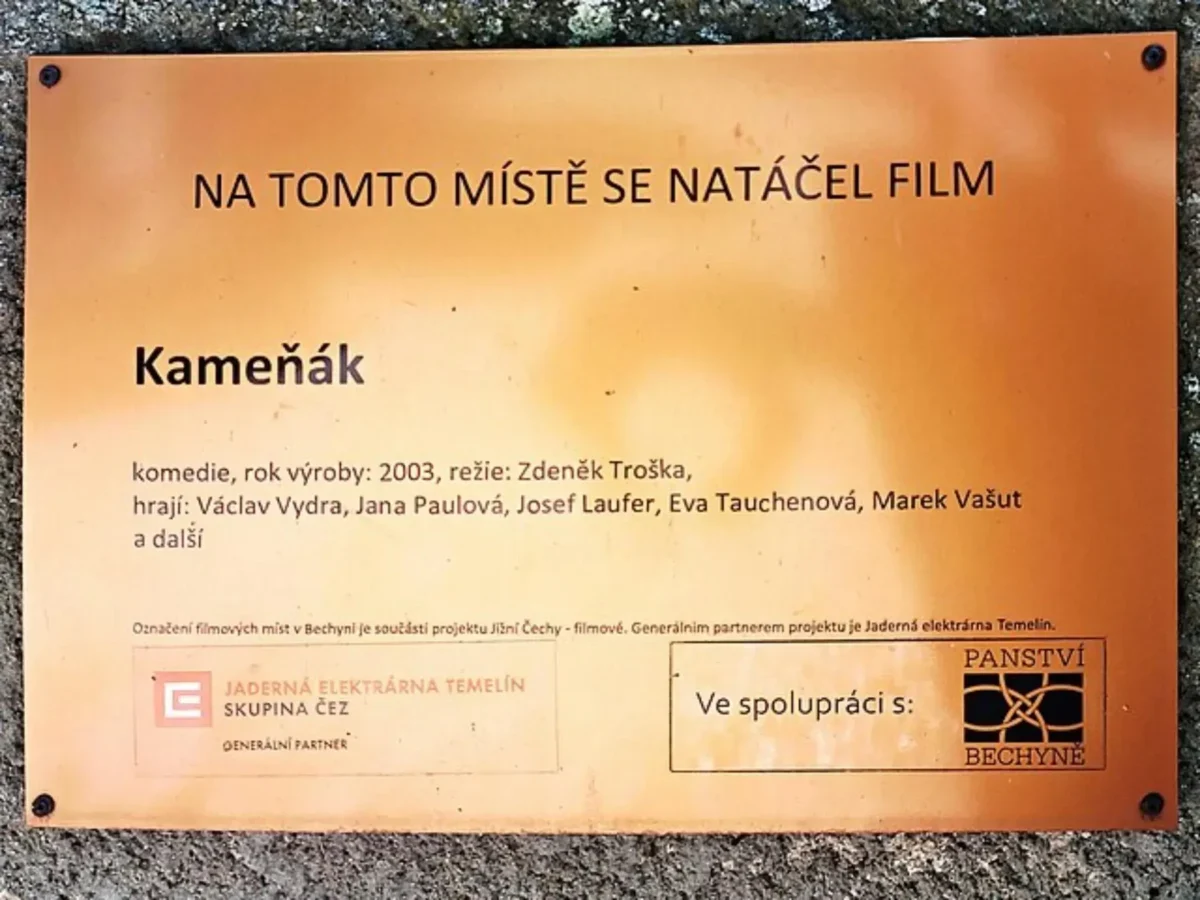 Cedule s informací o tom, že se tu točil Kameňák.