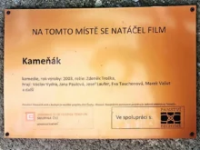 Cedule s informací o tom, že se tu točil Kameňák.