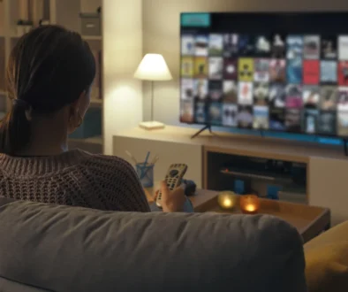 Žena sedí na pohovce před TV.