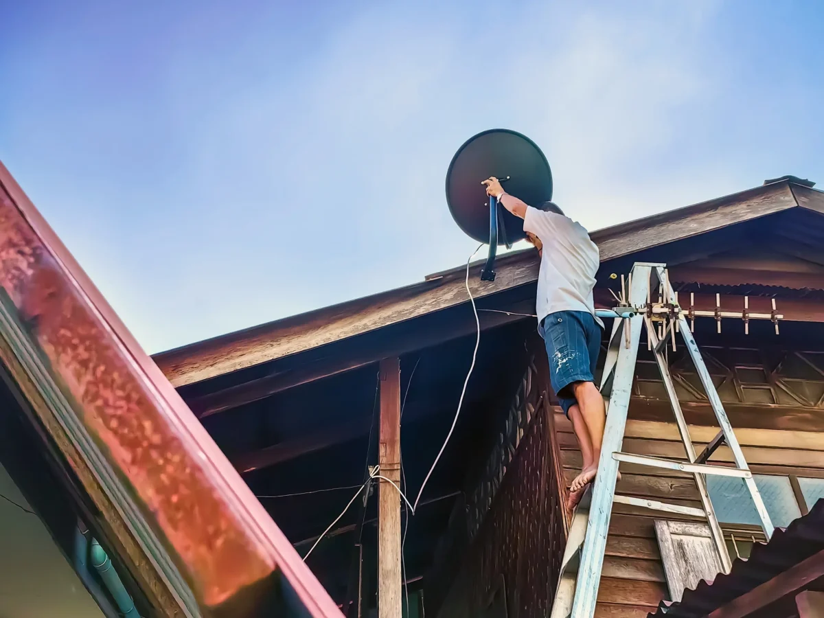 Muž montuje anténu. 