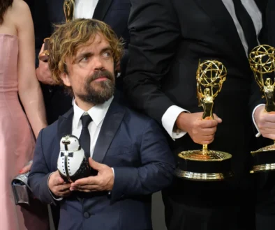 Peter Dinklage v ruce drží cenu.