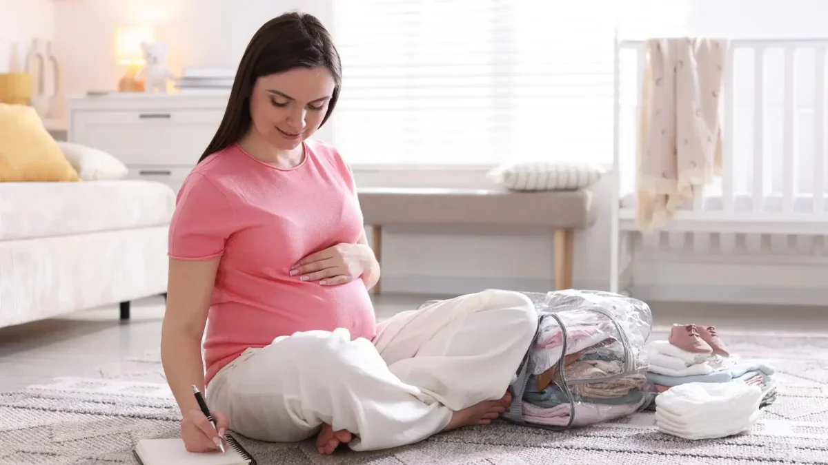 Těhotná žena sedí na zemi.