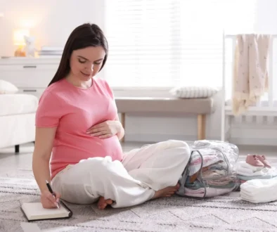 Těhotná žena sedí na zemi.