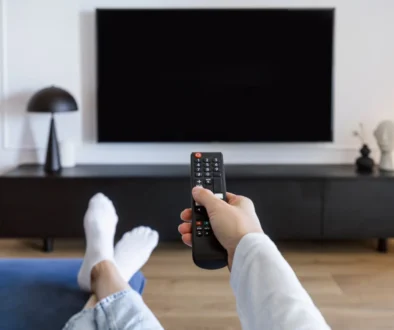 Muž sedí před tv s ovladačem v ruce.