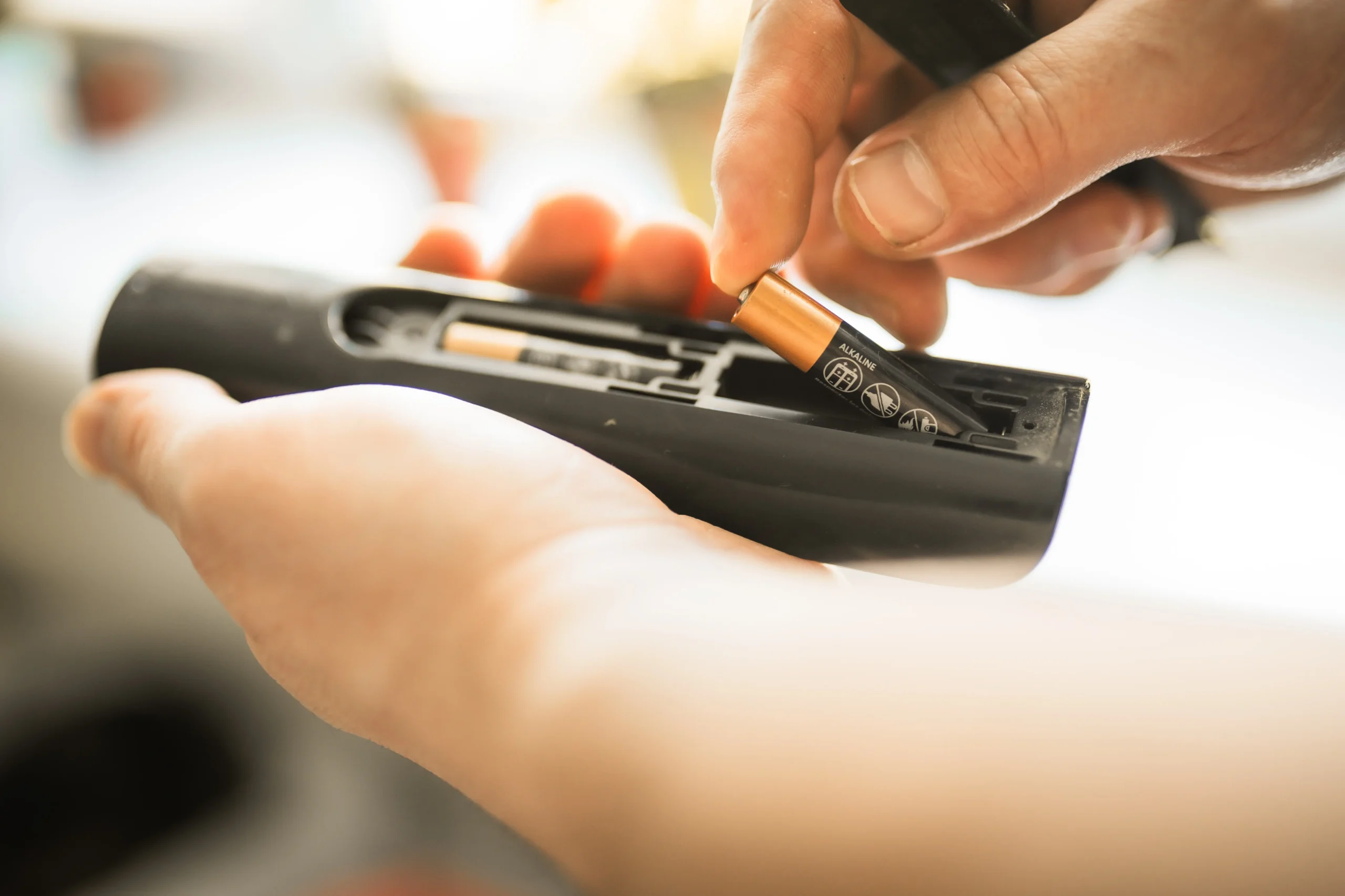 shutterstock_2620679067 1 | TVGURU.cz Muž vyměňuje baterie v ovladači od tv.