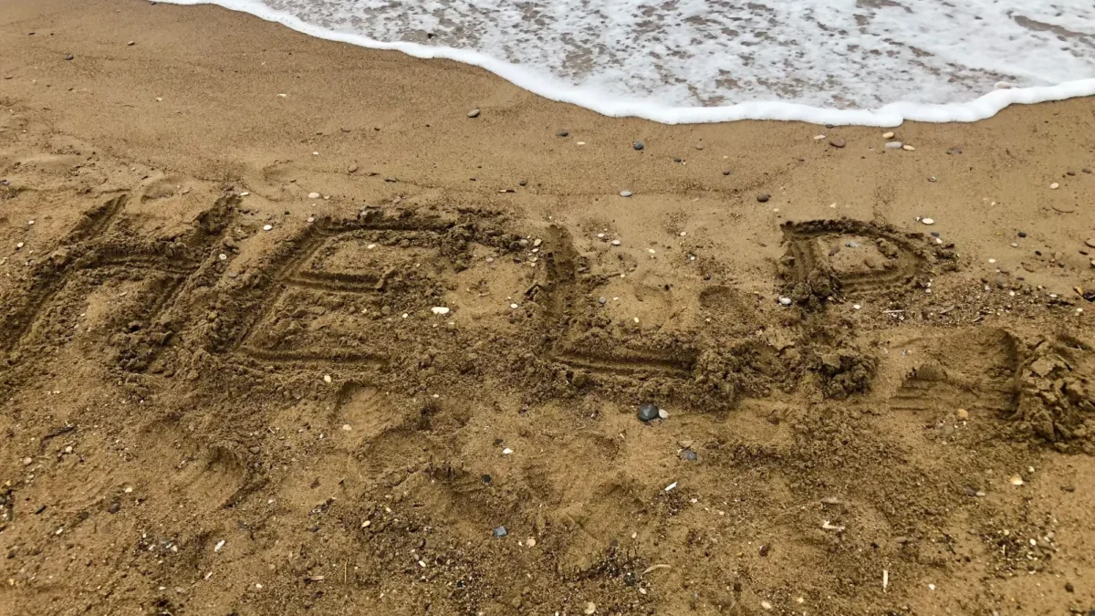 Nápis HELP na pláži.