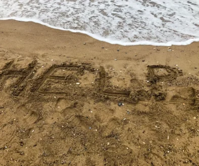 Nápis HELP na pláži.