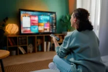 Žena sedí a kouká na televizi.