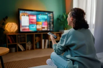 Žena sedí a kouká na televizi.