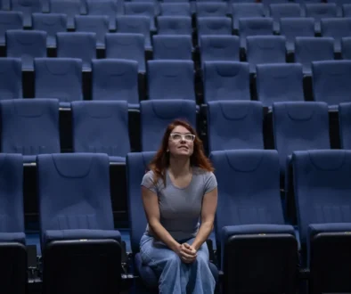 Žena sedí sama v kině.