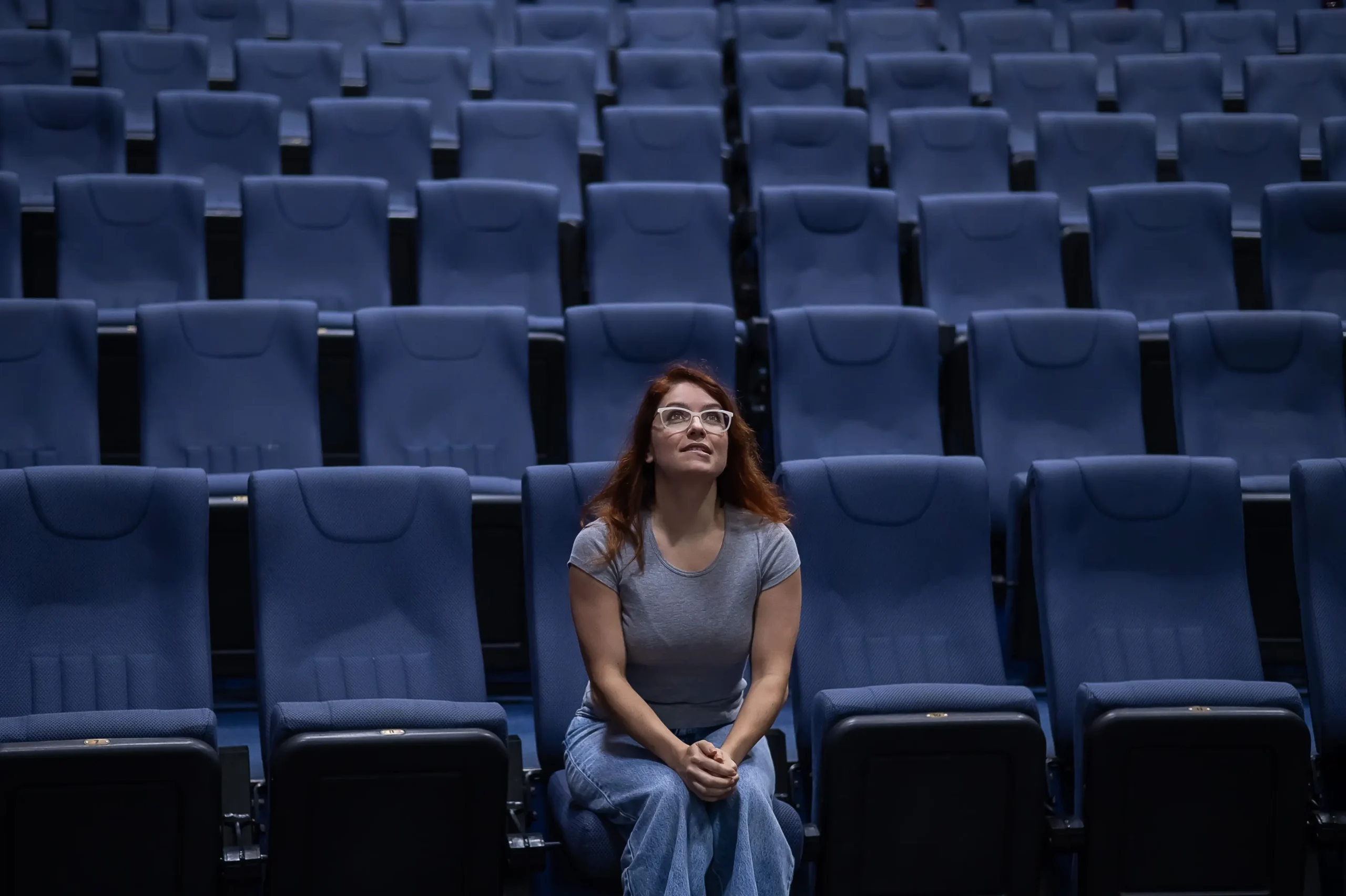 Žena sedí sama v kině.