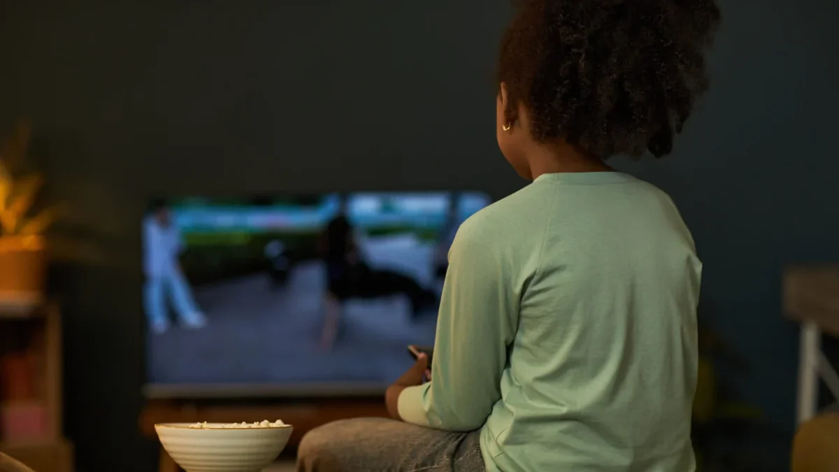 Dítě sedí před televizí.